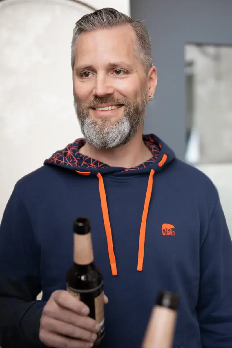 Arbeiter in blauem Overall mit Helm und Handschuhen bei der Arbeit.